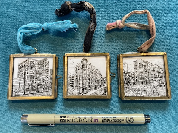 The same drawings in frames, being slightly longer than a Micron pen when laid side to side